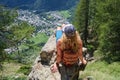 Woman hiker sits on rock above mountain town Courmayeur in Aosta valley, Italy. Royalty Free Stock Photo