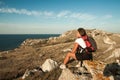 Woman hiker sits on seaside mountain rock Royalty Free Stock Photo