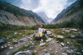 Woman Hiker sitting on a boulder, beautiful cloudy summer day. mountain landscape in the area of the Mestia. Georgia. Chalaadi Royalty Free Stock Photo