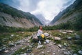 Woman Hiker sitting on a boulder, beautiful cloudy summer day. mountain landscape in the area of the Mestia. Georgia. Chalaadi Royalty Free Stock Photo