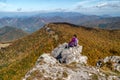 Woman hiker sitting on th rock on top of the hill Klak and looking on beautiful mountain landscape under Royalty Free Stock Photo