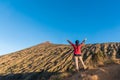 Woman hiker spreading hand, enjoy and happy with mountain top view after finished climbing at mount Rinjani