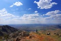 Woman hiker standing admiring a mountaintop view looking out over distant ranges of mountains Royalty Free Stock Photo