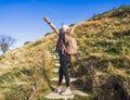 Woman hiker standing with her arms up on her way to the top. Conceptual design. Royalty Free Stock Photo