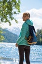 Woman hiker stands on the coast of the lake