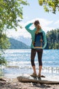 Woman hiker stands on the coast of the lake