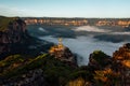 Woman hiker stands on a rocky pagoda ihigh in mountains with fog filled valley