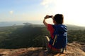 Woman hiker taking photo with cellphone on mountain top Royalty Free Stock Photo