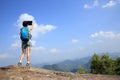 Woman hiker taking photo with digital camera at mountain peak Royalty Free Stock Photo