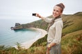 Woman hiker taking photo in front of ocean view landscape Royalty Free Stock Photo