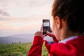 Woman hiker taking photo with smartphone Royalty Free Stock Photo