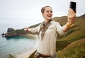 Woman hiker taking selfie in front of ocean view landscape Royalty Free Stock Photo