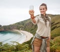 Woman hiker taking selfie with smartphone in front of ocean Royalty Free Stock Photo