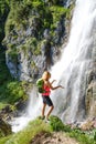 Woman hiker touching water drops at Dalfazer waterfall, Austria Royalty Free Stock Photo