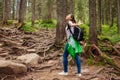 Woman hiker walking through mountain forest path surrounded with roots in Carpathians. Traveler feels happy Royalty Free Stock Photo