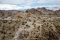 Woman hiker walks along a dirt trail through the Alabama Hills to the The Mobius Arch Loop Trailhead Royalty Free Stock Photo