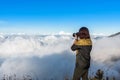 Woman hiker wear jacket, taking photograph, enjoy and happy with mountain top view after finished climbing at mount Rinjani.