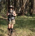 Woman HIker With Wide Brimmed Hat And Tall Gaiters Hikes In Forest