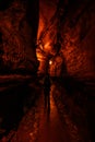 Woman Hikes Through Dimly Light Cave Tunnel