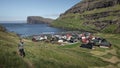 Woman hikes at the village of TjÃ¶rnuviÂ­k on Streymoy on the Faroe Islands during the day