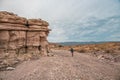 Woman Hikes In Wide Wash Below Tan Cliff