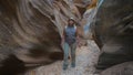 Woman Hiking On Dry River Gorge With Smooth And Wavy Rocks Of The Canyon