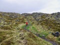 Woman hiking on famous coastal trail from Arnarstapi to Hellnar. Iceland.