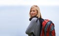 Woman, hiking and portrait for travel, adventure and wellness on a cloudy sky or grey background in winter. Face of a Royalty Free Stock Photo