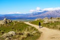 Woman hiking up the mountain paths to the top, with beautiful views of the landscape in the background Royalty Free Stock Photo