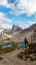 Woman hiking with the view on small, navy blue lakes at the bottom of the valley in Italian Alps. Royalty Free Stock Photo