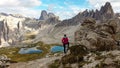 Woman hiking with the view on small, navy blue lakes at the bottom of the valley in Italian Alps. Royalty Free Stock Photo