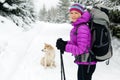 Happy woman walking in winter forest with dog Royalty Free Stock Photo