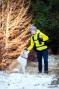 Woman hiking in winter forest with dog Royalty Free Stock Photo