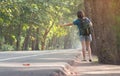 Woman hitchhiker with backpack sign thumb on highway road.