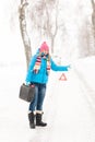 Woman hitchhiking on road snow gas can Royalty Free Stock Photo