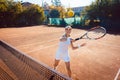 Woman hitting the tennis ball on the court