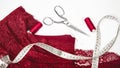 Woman hobby. Workplace of seamstress for sewing underwear. Red, burgundy lace fabric, scissors and sewing accessories Royalty Free Stock Photo