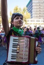 Woman with a Hohner concerto accordion raising her fist at International Women's Day 8M - Santiago, Chile - Mar 08, 2020