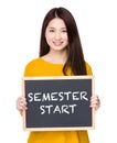 Woman hold blackboard showing phrases of semester start