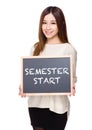 Woman hold with chalkboard showing phrases of semester start