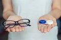 Woman hold contact lenses and glasses in hands. concept of choice of vision protection Royalty Free Stock Photo