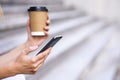 Woman hold cup of coffee and smart phone on street, with space for text