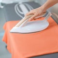 Woman hold Electric hot iron press T shirt clothes on ironing board, Intelligent automatic steam iron. Laundry, Housework, Royalty Free Stock Photo