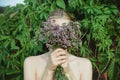 Woman hold fresh cutting oregano plant bouquet and and hide face Royalty Free Stock Photo