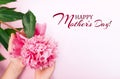 Woman hold in hands a pink peony, leaves on a white background. Fresh flowers. Inscription Happy Mother`s Day. Advertising banner Royalty Free Stock Photo