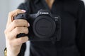 Woman hold new model canon EOS R5 camera in hand closeup