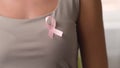 Woman hold pink ribbon. Close up view of symbol of national breast canser awareness month in october