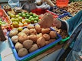 Woman hold potato and collection of potatos in the blue basket. Collection of lime at the market Royalty Free Stock Photo