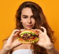 Woman eat burger sandwich with hungry mouth on yellow background Royalty Free Stock Photo