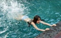 Woman hold on to the edge of the swimming pool and splashing water with her feet Royalty Free Stock Photo